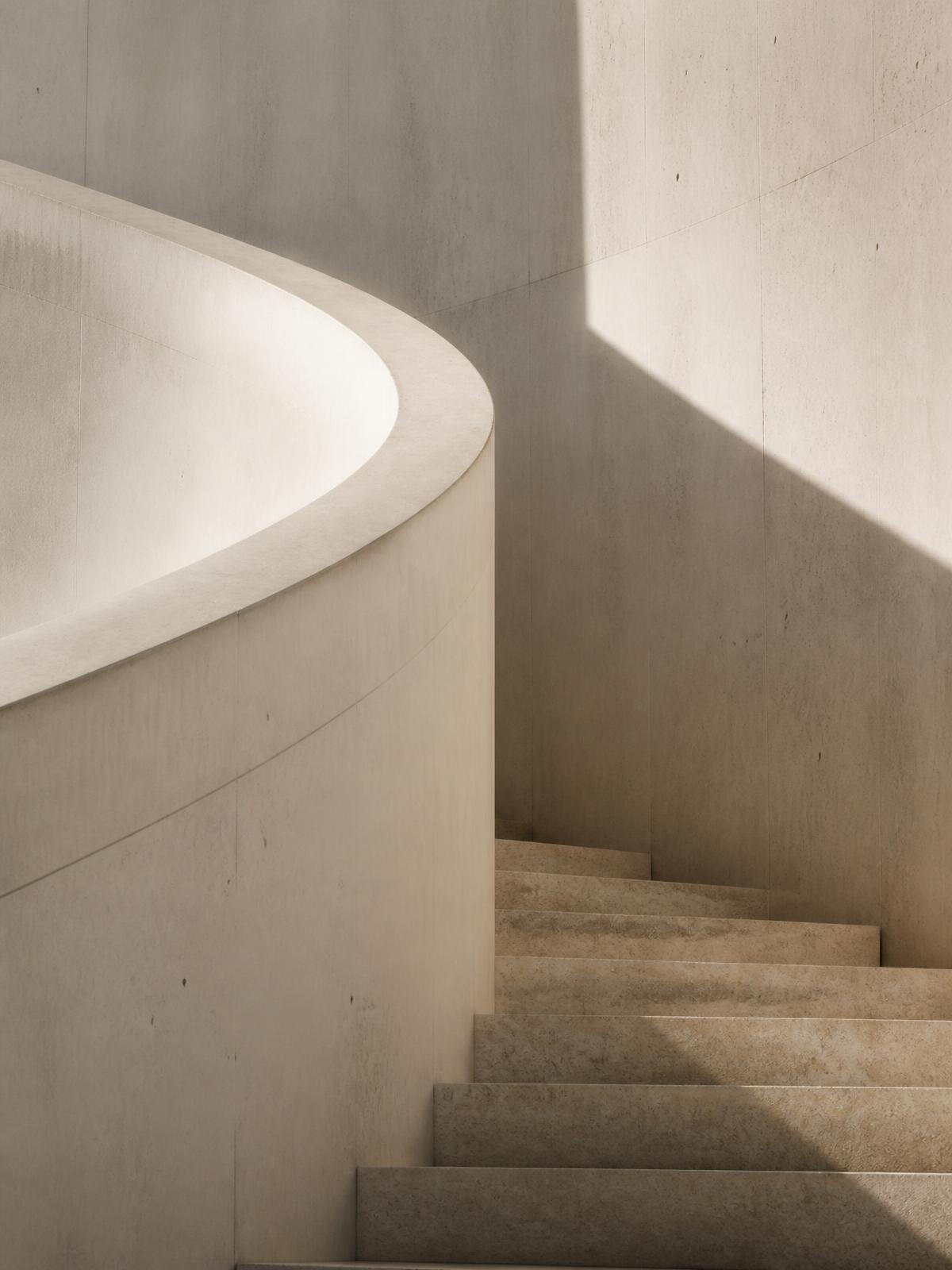 Curved concrete stairwell in soft morning light with long shadows